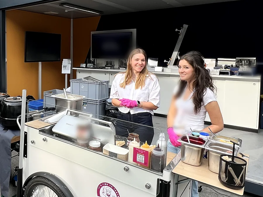 Zwei Crew-Mitglieder von CateringLovers an ihrer Live-Cooking-Station auf einem Messestand