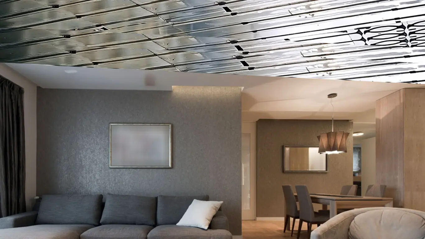 Soggiorno moderno con divano grigio, pareti decorate, lampada a sospensione e impianto di riscaldamento a soffitto visibile.