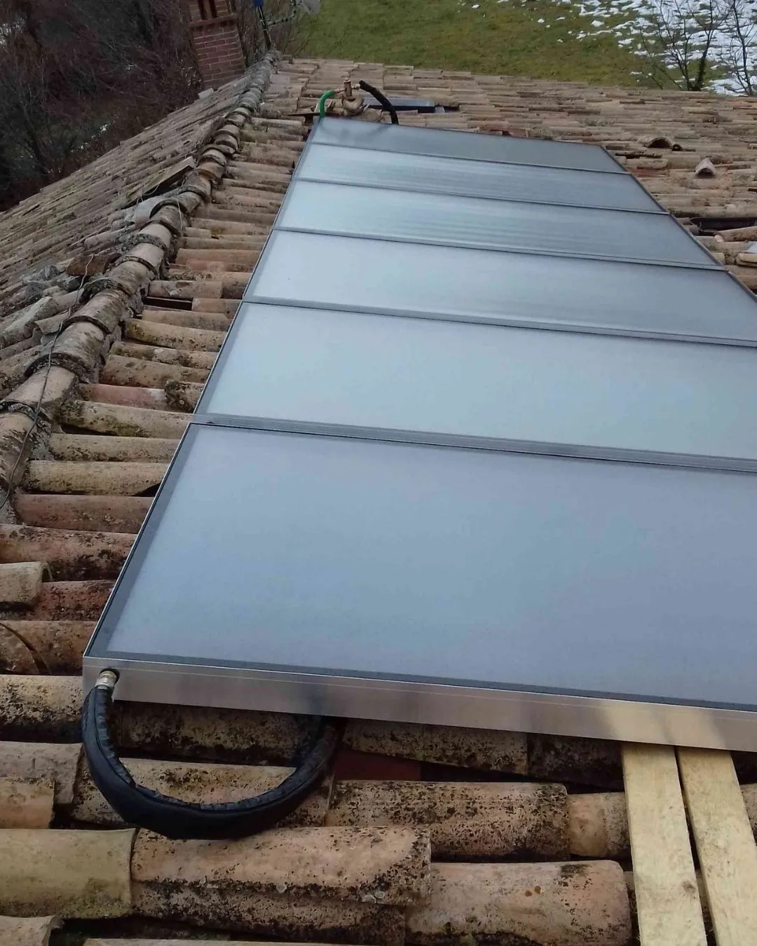 Pannello solare installato su un tetto con tegole in terracotta.