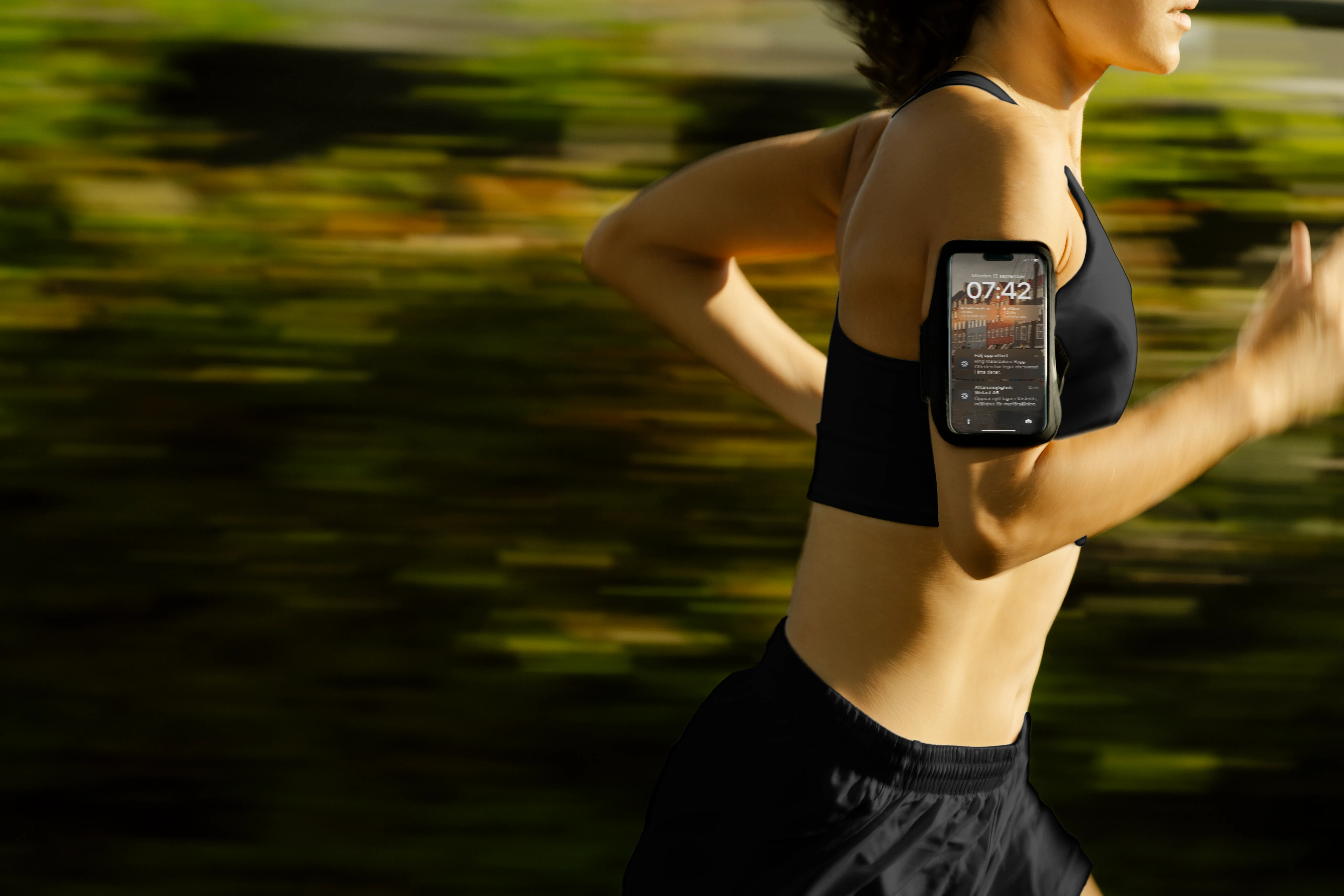 Löpare med mobilen i armband som visar notiser från Aira