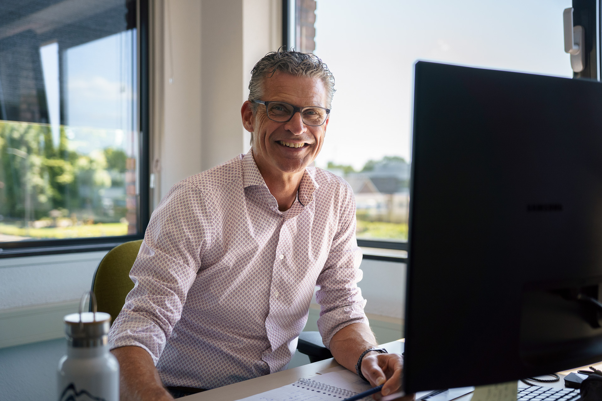 Man smiling behind PC