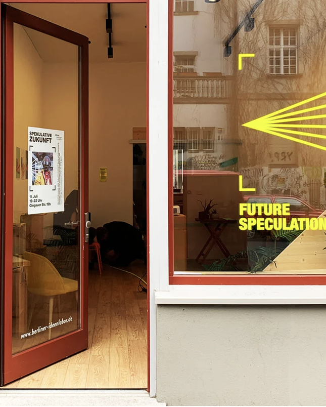 A workplace with open door and yellow text on glass window