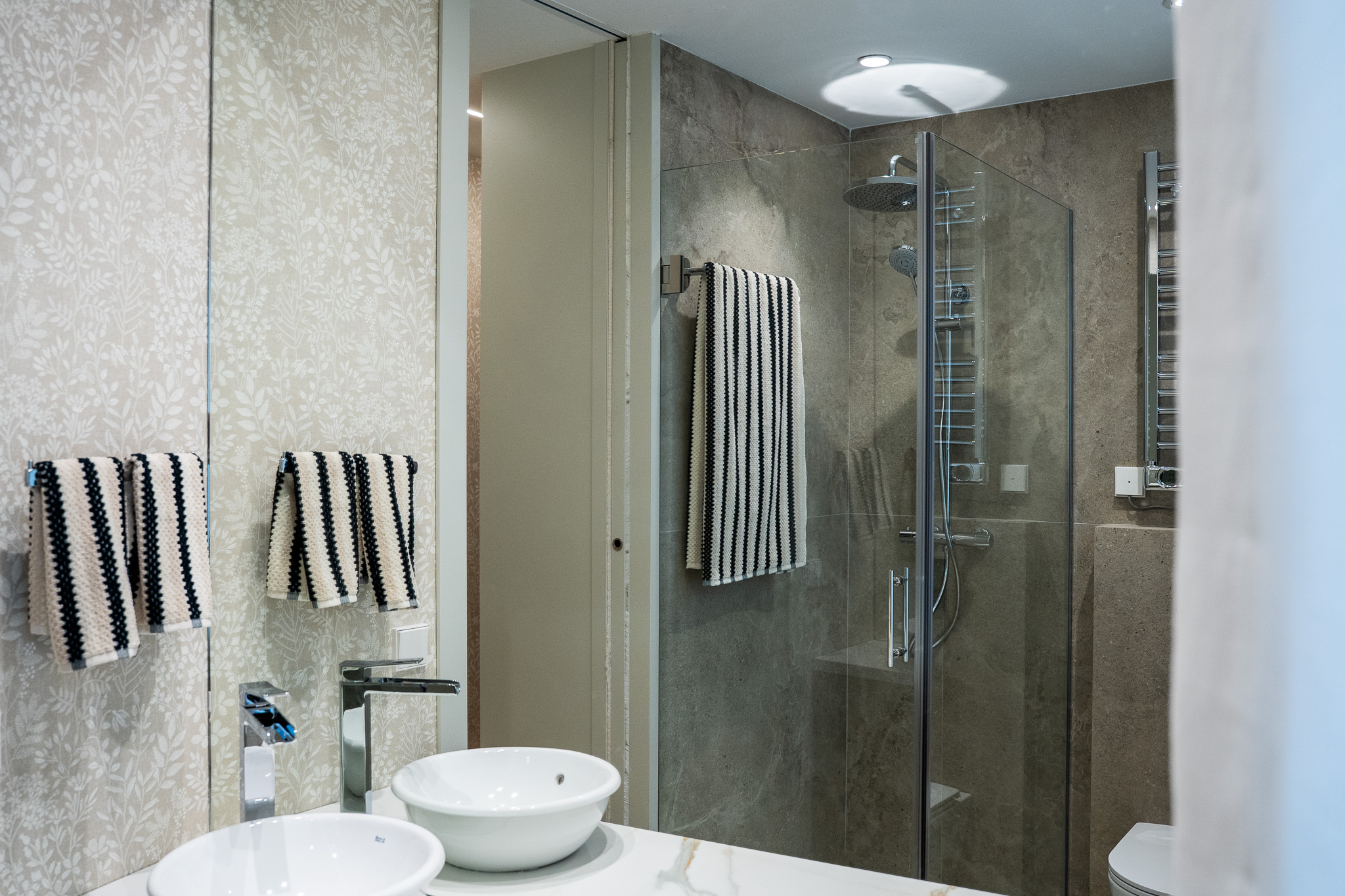 Baño con dos lavabos de sobreponer y ducha al fondo