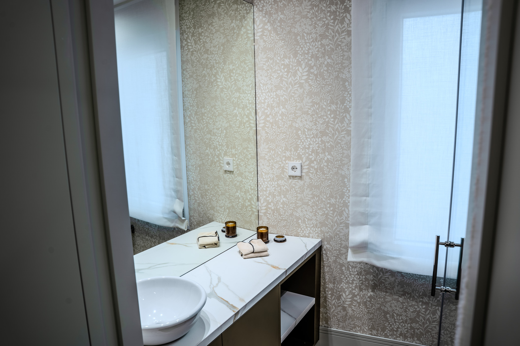 Baño con ventana, papel vegetal y encimera clara