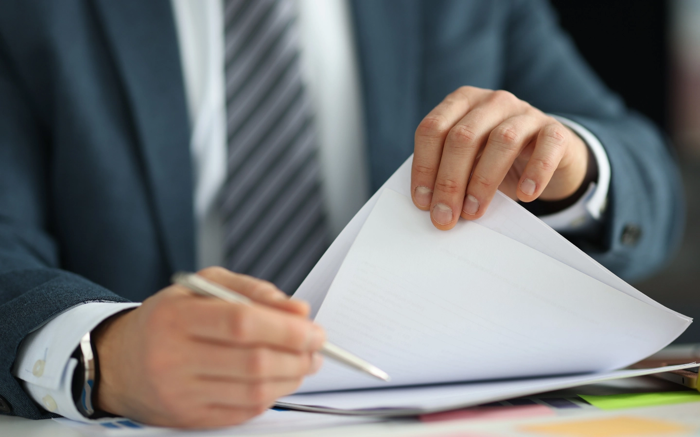 Image of person handling papers with a pen