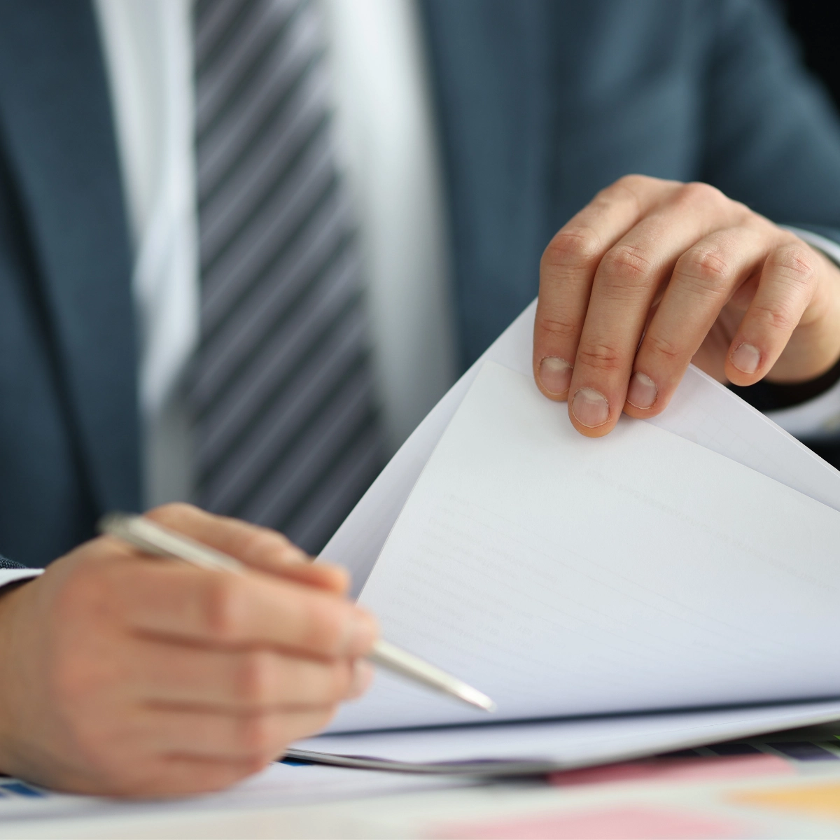 Image of person handling papers with a pen