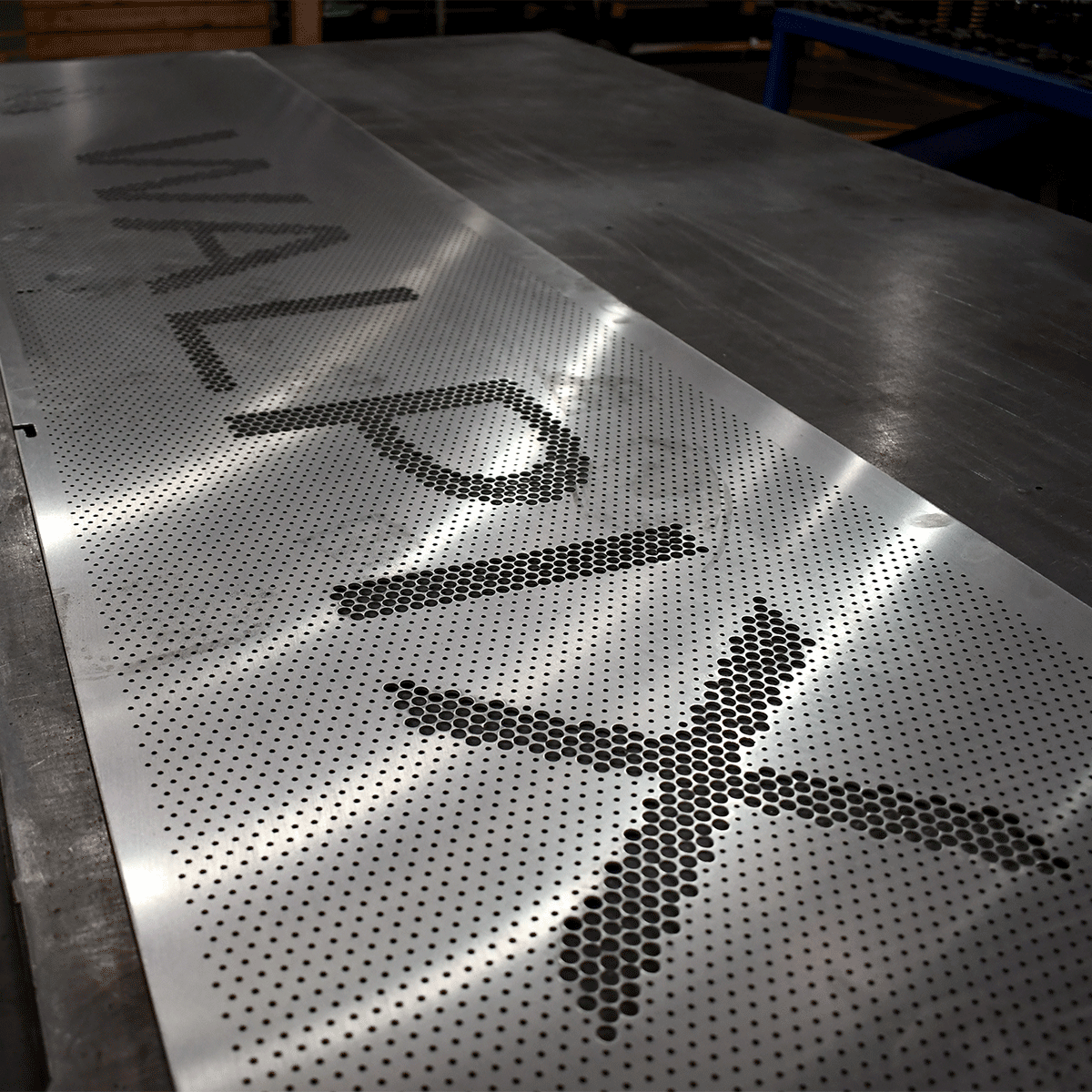 Sheet of perforated metal with the word 'WALPIX' formed by varying hole sizes.