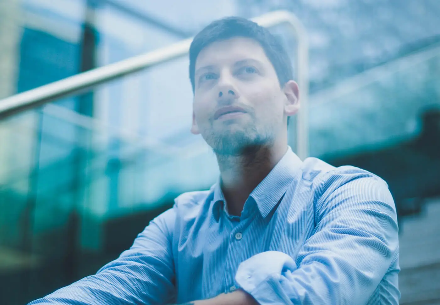 Man in blue shirt looking thoughtfully