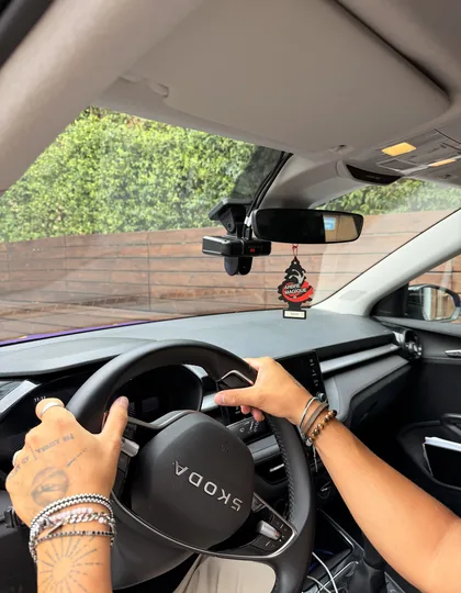 Mani sul volante di un'auto BRUM con la dashcam montata vicino allo specchietto