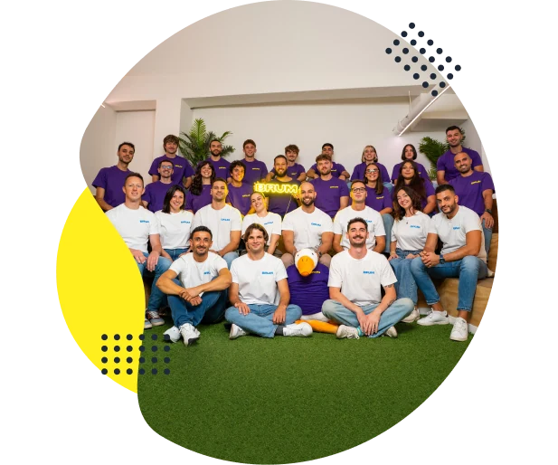 Tutto il team BRUM in maglie viola e bianche con l'insegna luminosa BRUM