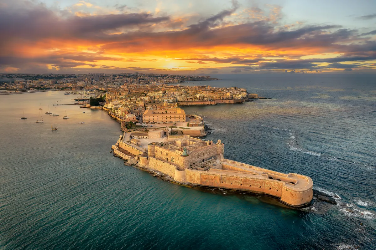 Vista aerea di Siracusa con il Castello Maniace e l'isola di Ortigia al tramonto