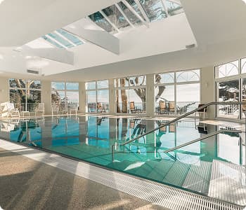 Piscine intérieure d’un hôtel en Bretagne avec vue sur la mer, cadre idéal pour allier travail et détente lors de séminaires ou événements professionnels