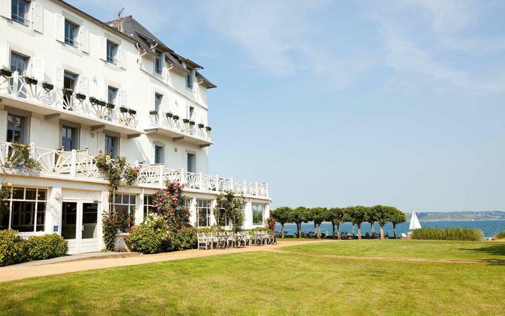 White facade of the Grand Hôtel des Bains in Locquirec, Finistère, with garden and sea view