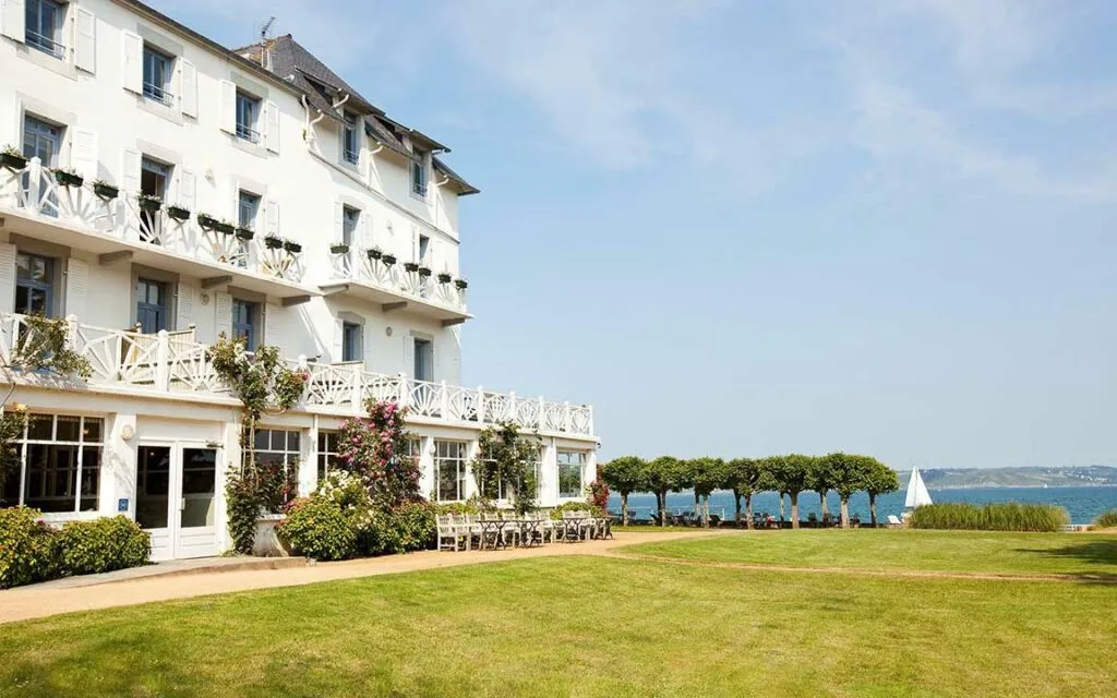 Façade blanche du Grand Hôtel des Bains à Locquirec avec jardin et vue sur la mer, dans le Finistère