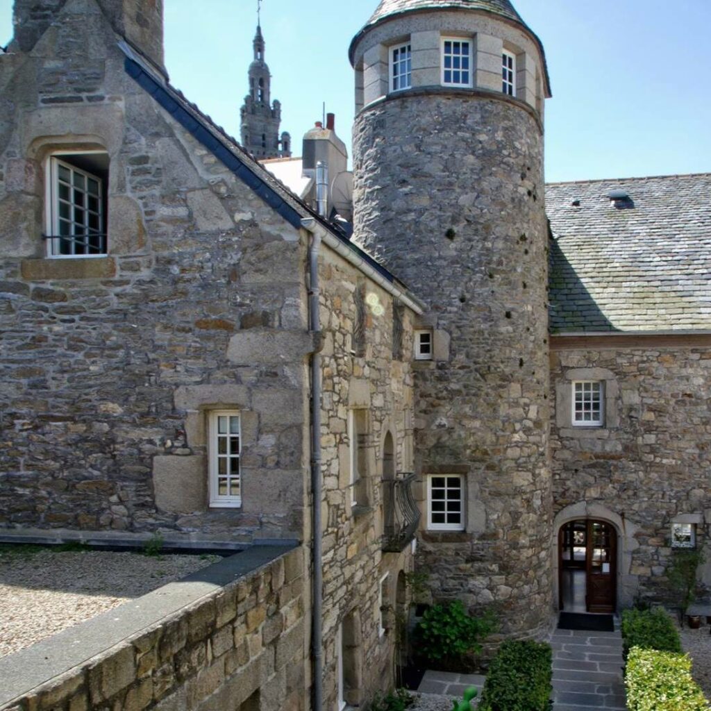 Façade en pierre de l’hôtel Le Temps de Vivre à Roscoff, dans une bâtisse historique du XVIe siècle avec tour ronde et fenêtres à meneaux