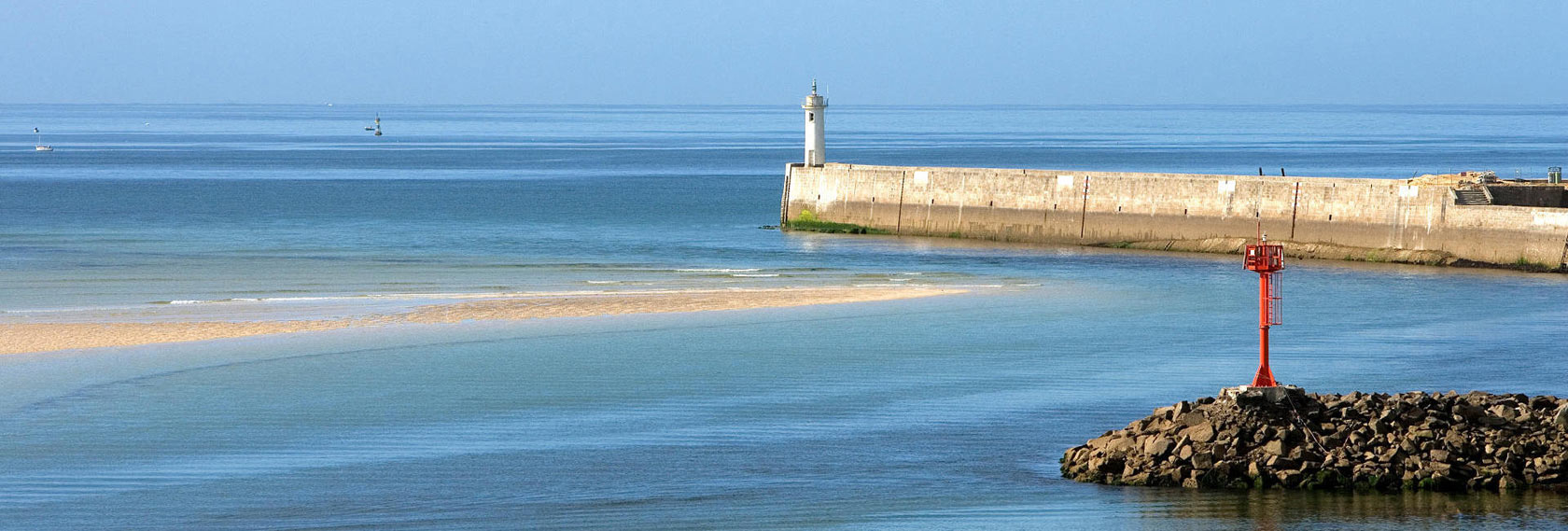 Vue paisible sur la mer et le phare d’Audierne depuis la côte, invitation à la détente, à la marche et aux activités en bord de mer.