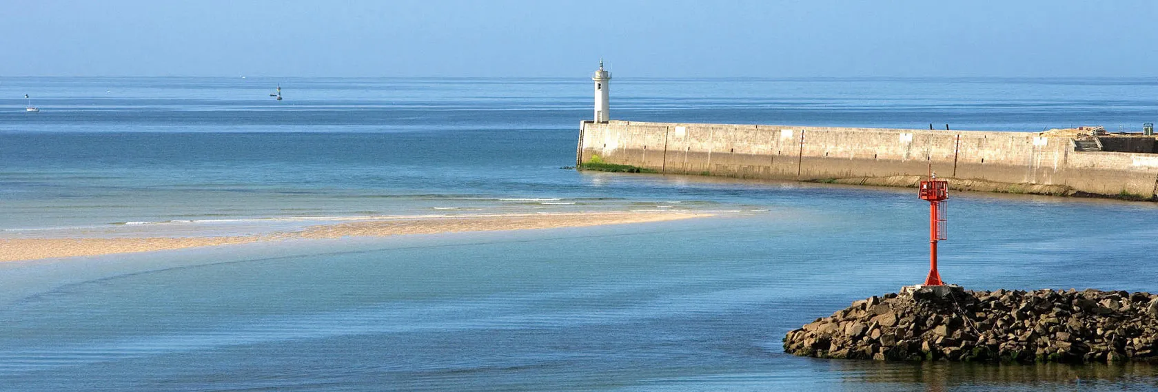 Vue paisible sur la mer et le phare d’Audierne depuis la côte, invitation à la détente, à la marche et aux activités en bord de mer.