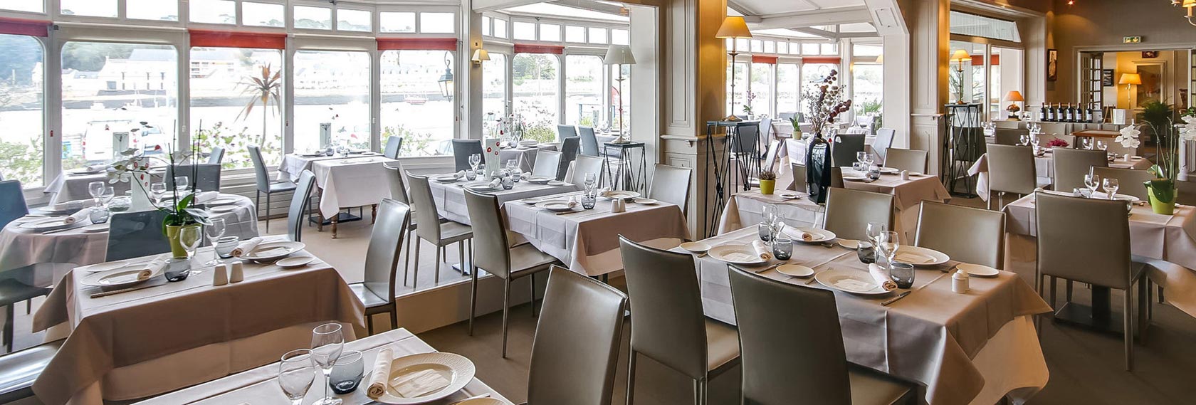 Salle lumineuse du restaurant avec vue sur le port d’Audierne, ambiance élégante et chaleureuse pour une immersion dans l’art de vivre breton.
