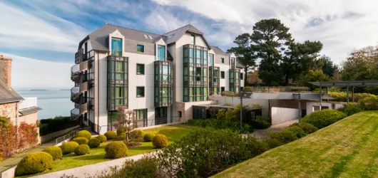 Vue extérieure de l’hôtel Villa Les Hydrangeas à Perros-Guirec, bâtiment contemporain entouré de verdure avec vue sur la mer.