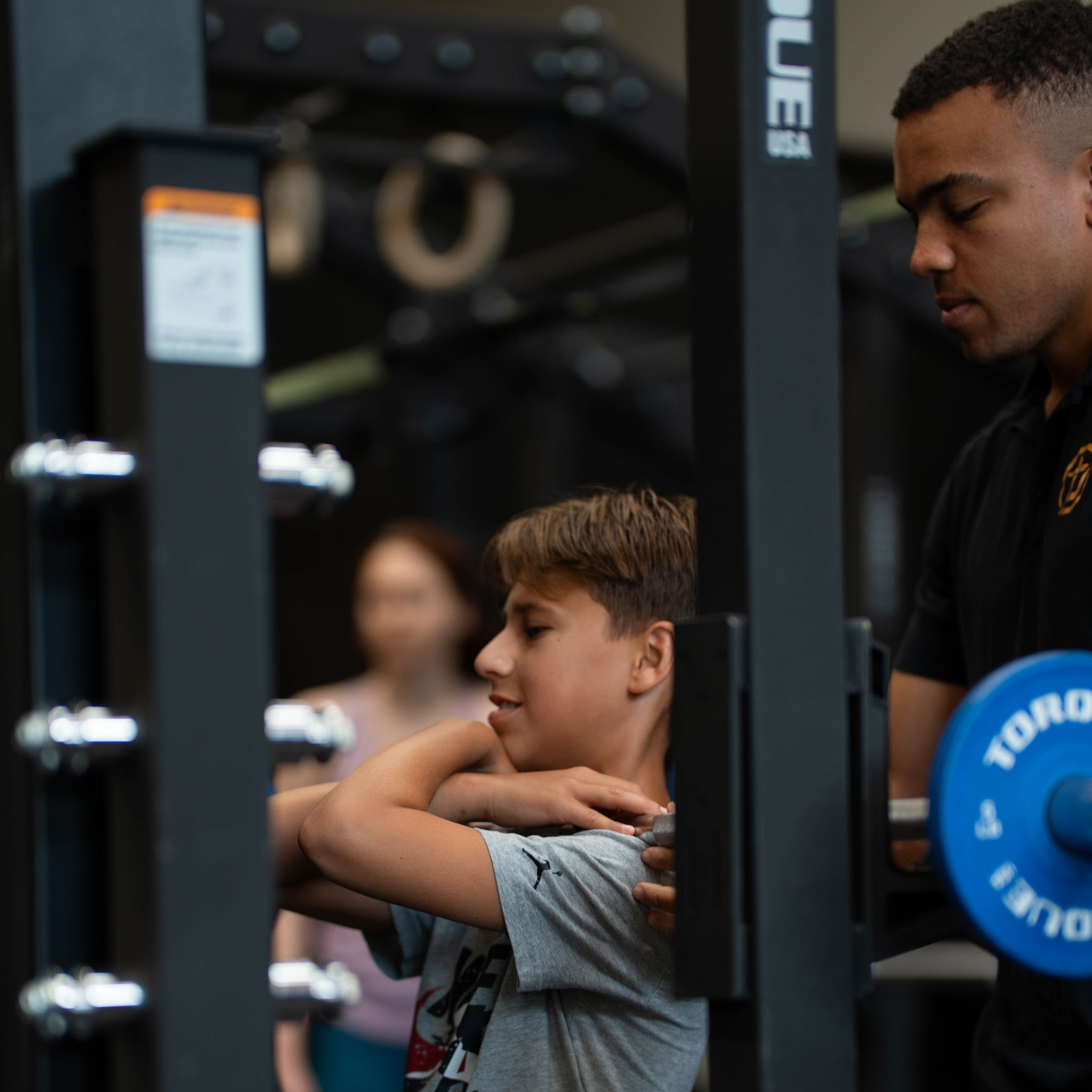 Personal trainer coaching a client through loaded strength training after physical therapy