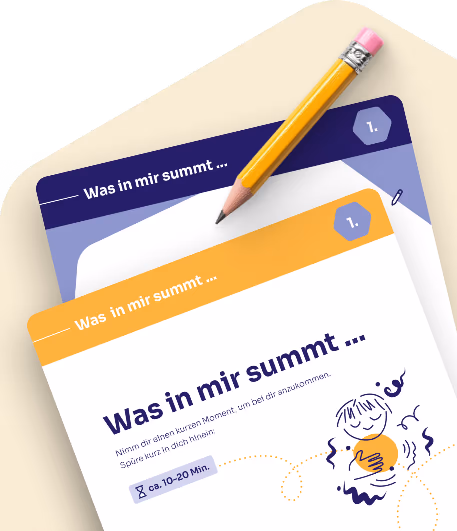 Stift liegt auf zwei Karten mit dem Text ‚Was in mir summt ...‘ und einer Illustration einer lächelnden Person, die die Hände aufs Herz legt.