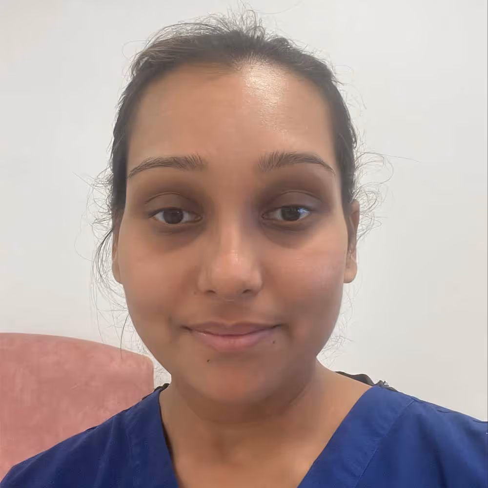 A person wearing a blue shirt smiles at the camera.