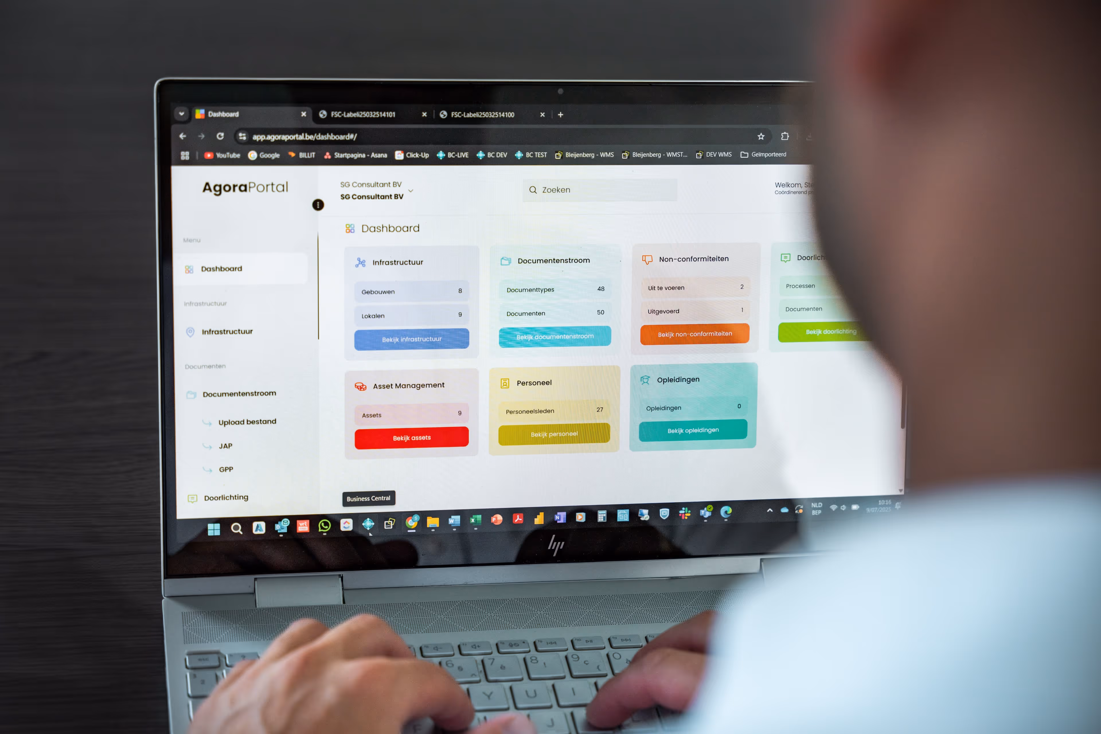 Persoon bekijkt een kleurrijk dashboard op een laptop met verschillende bedrijfsmodules.
