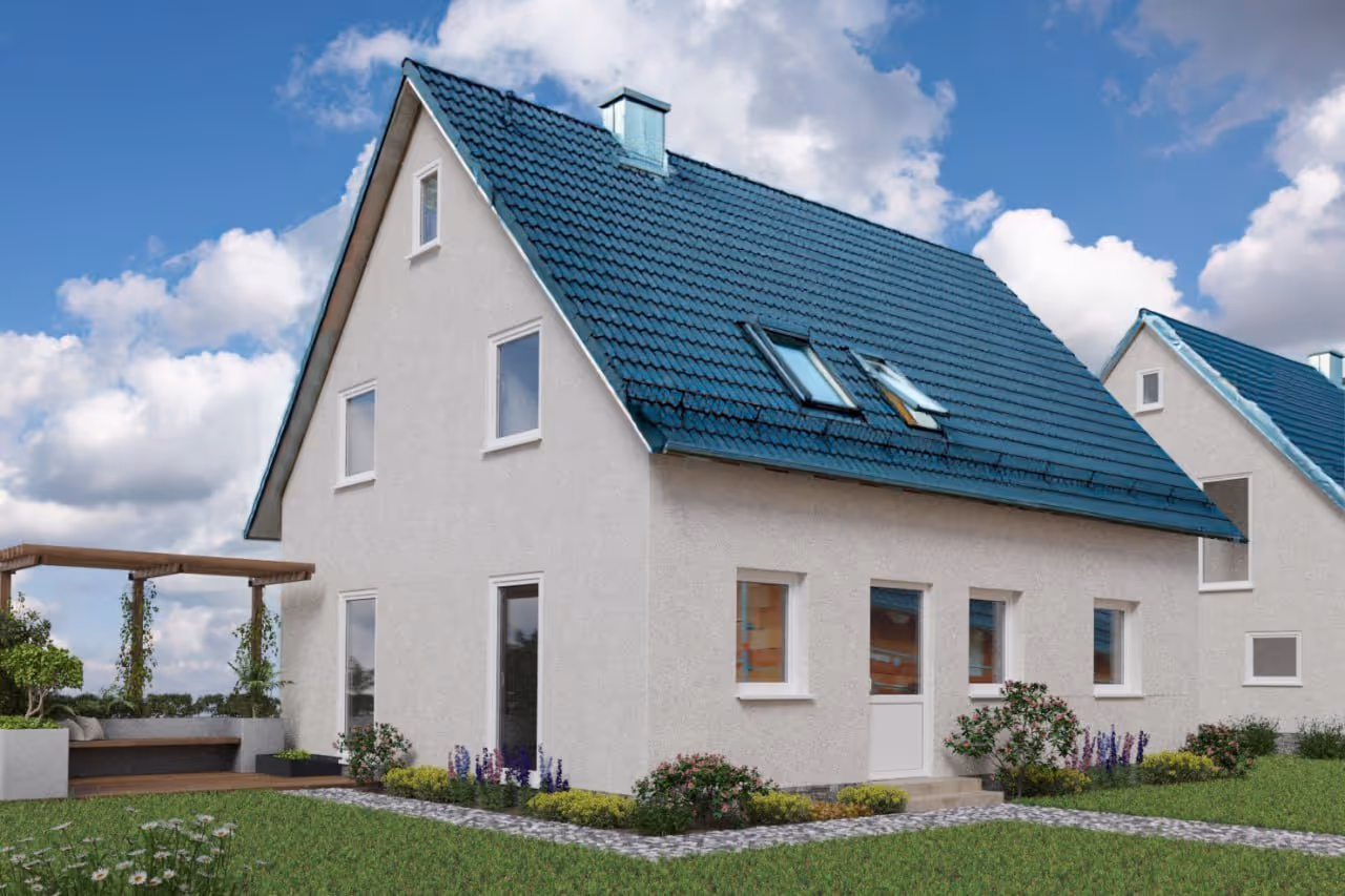 Modernes Einfamilienhaus mit weißer Fassade, blaugrauem Dach und gepflegtem Garten bei blauem Himmel.
