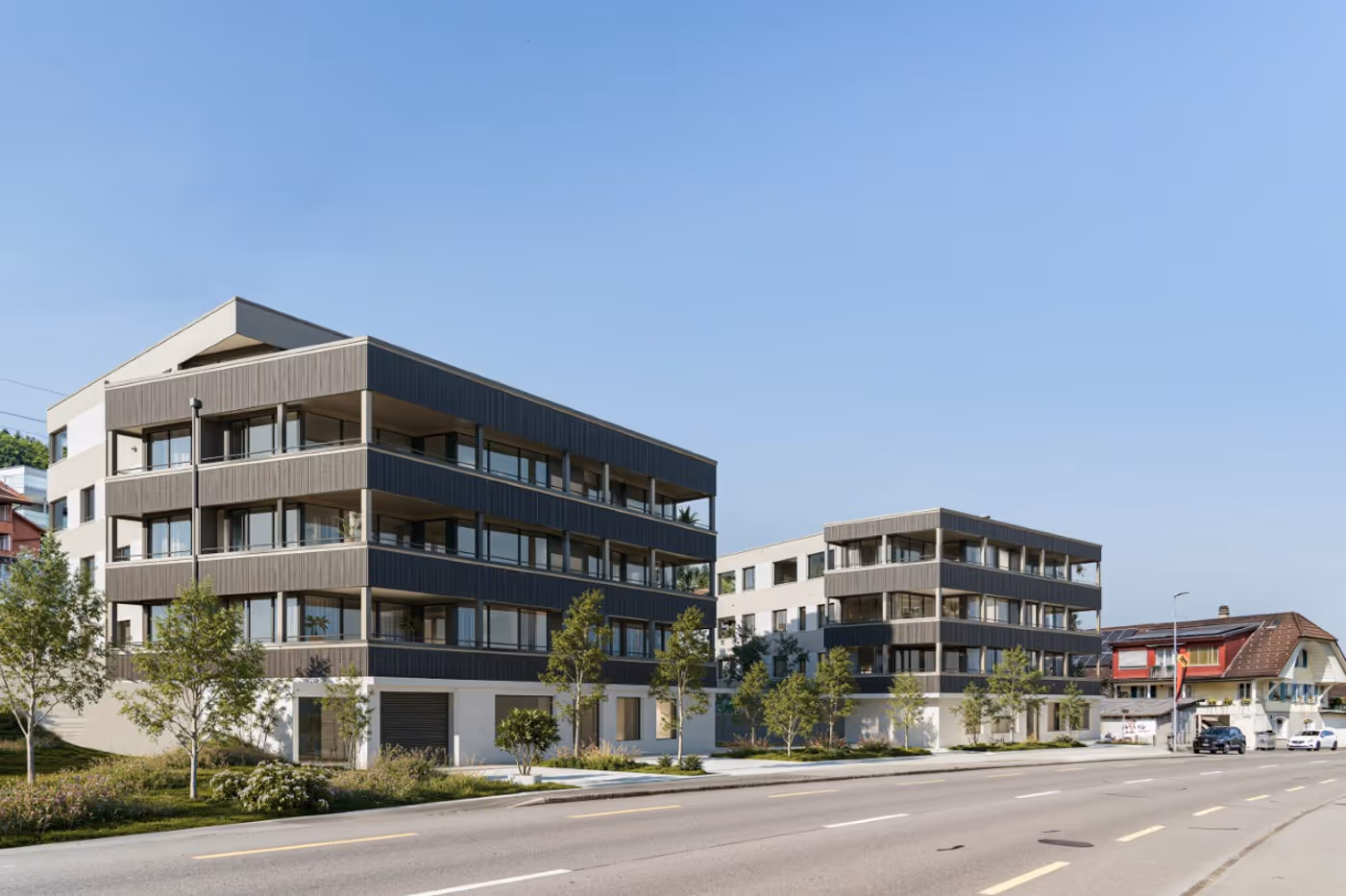 Moderne Wohngebäude mit Holzverkleidung entlang einer Straße unter klarem blauem Himmel.