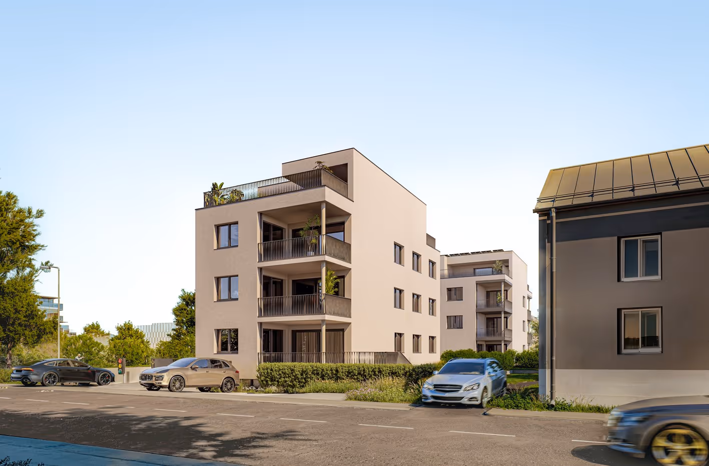 Modernes Wohngebäude mit Balkonen und mehreren geparkten Autos an einer ruhigen Straße bei klarem Himmel.