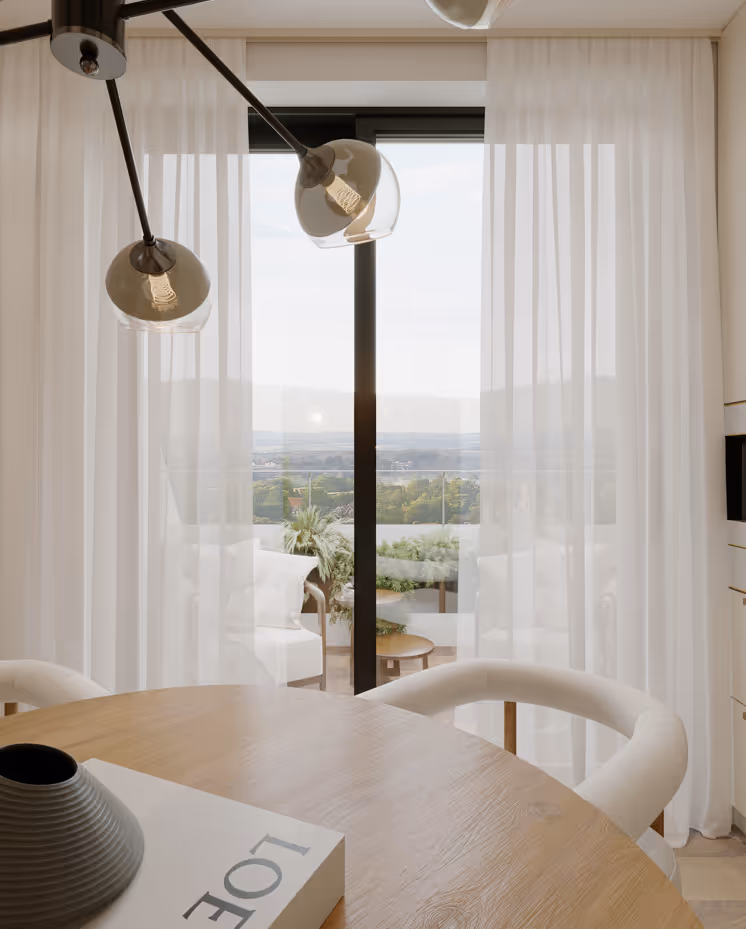 Moderner Essbereich mit rundem Holztisch, weißen Stühlen, Hängeleuchte und blick durch transparente Vorhänge auf Balkon mit Pflanzen und weiter Landschaft.