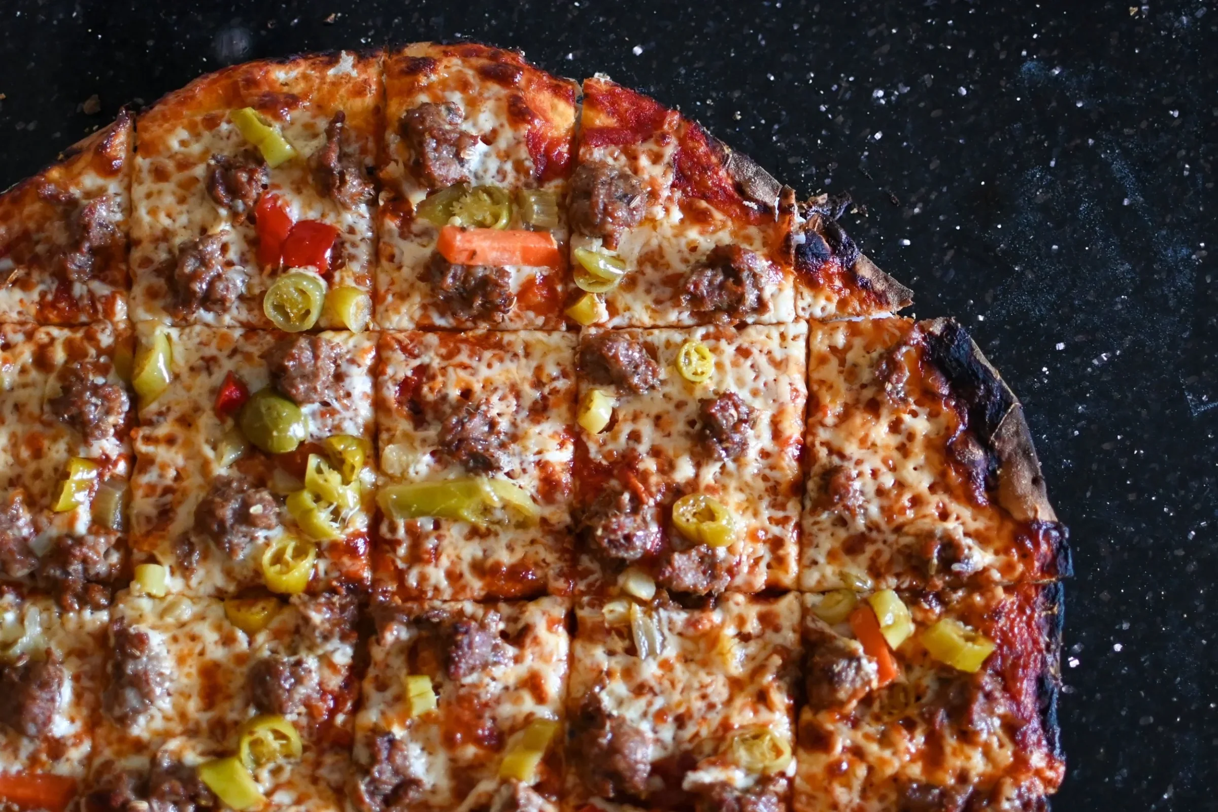 Crust Fund tavern-cut pizza on a starry black surface