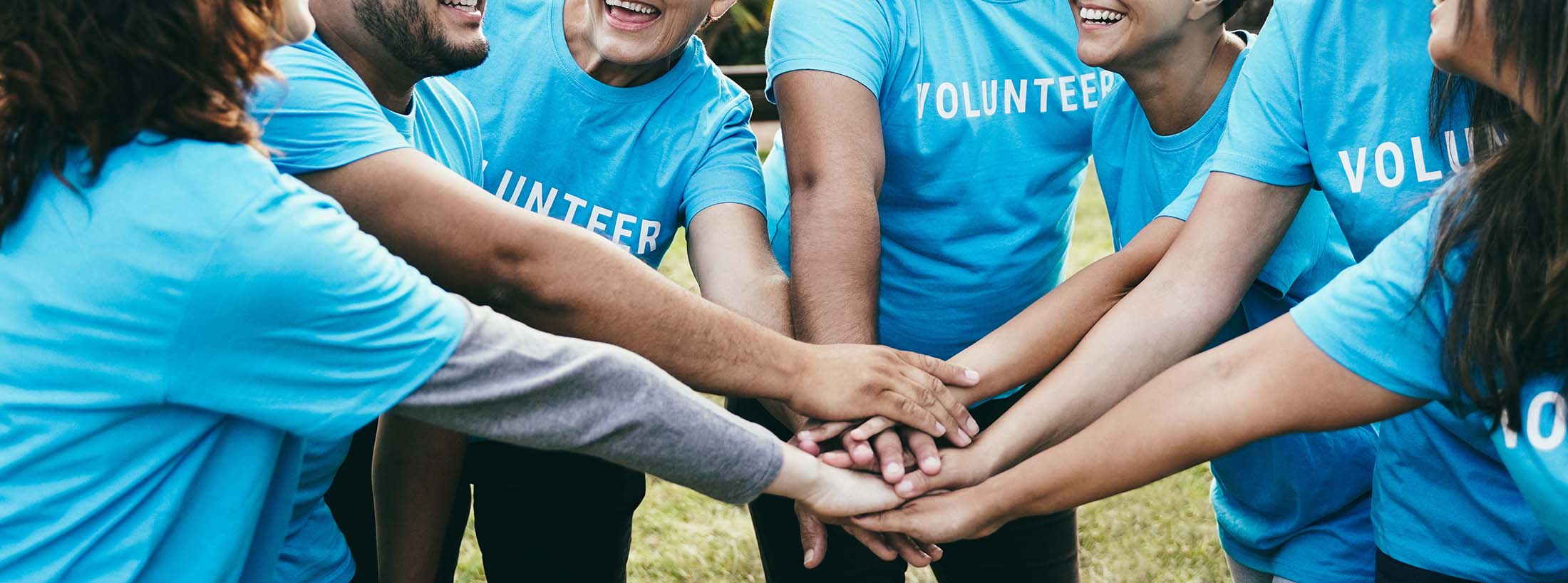 A group of volunteers putting hands together
