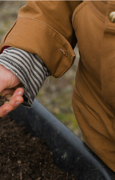 A close up shot of someone's hand in the soil
