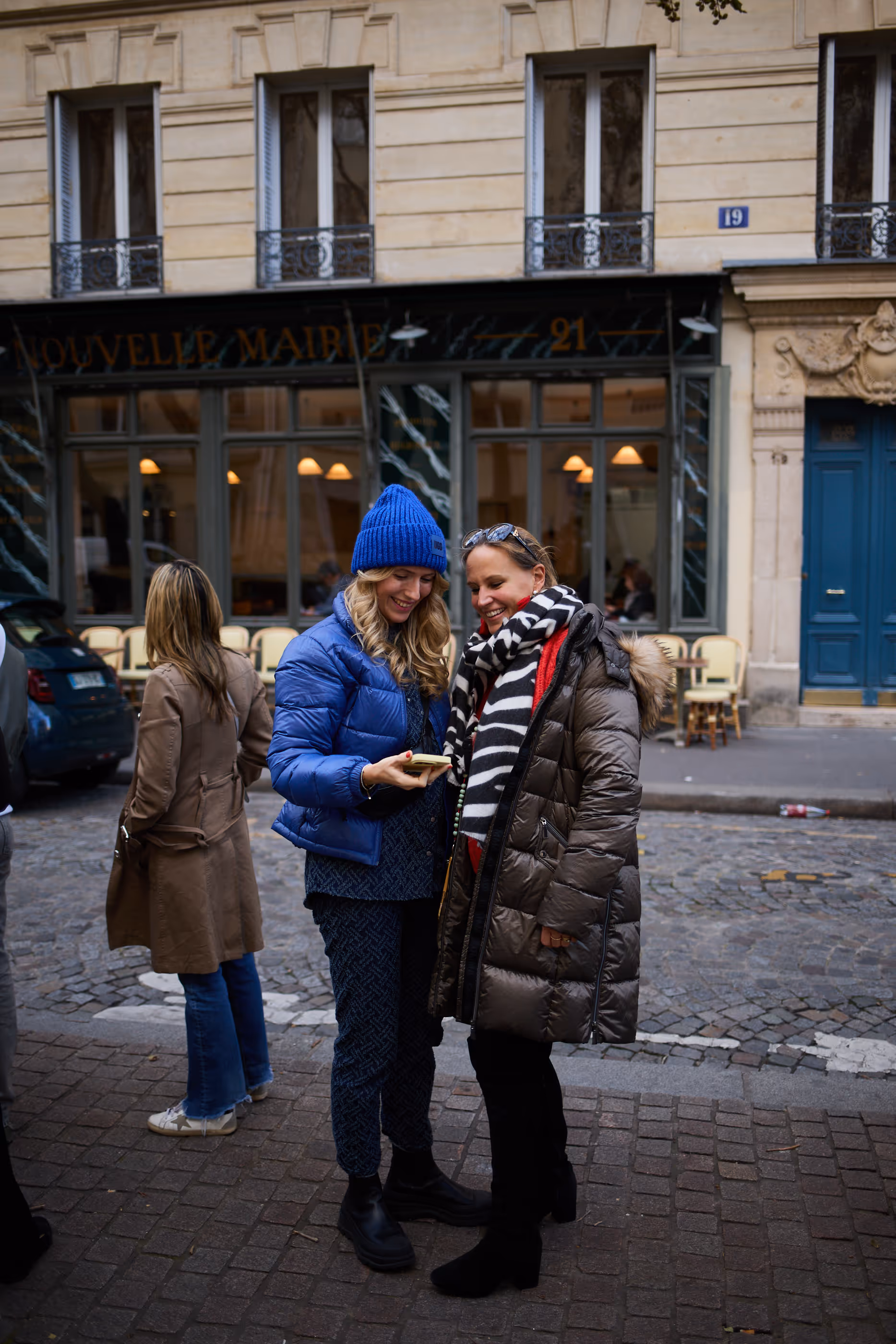 Two women looking at a phone on the emily in paris walking tour