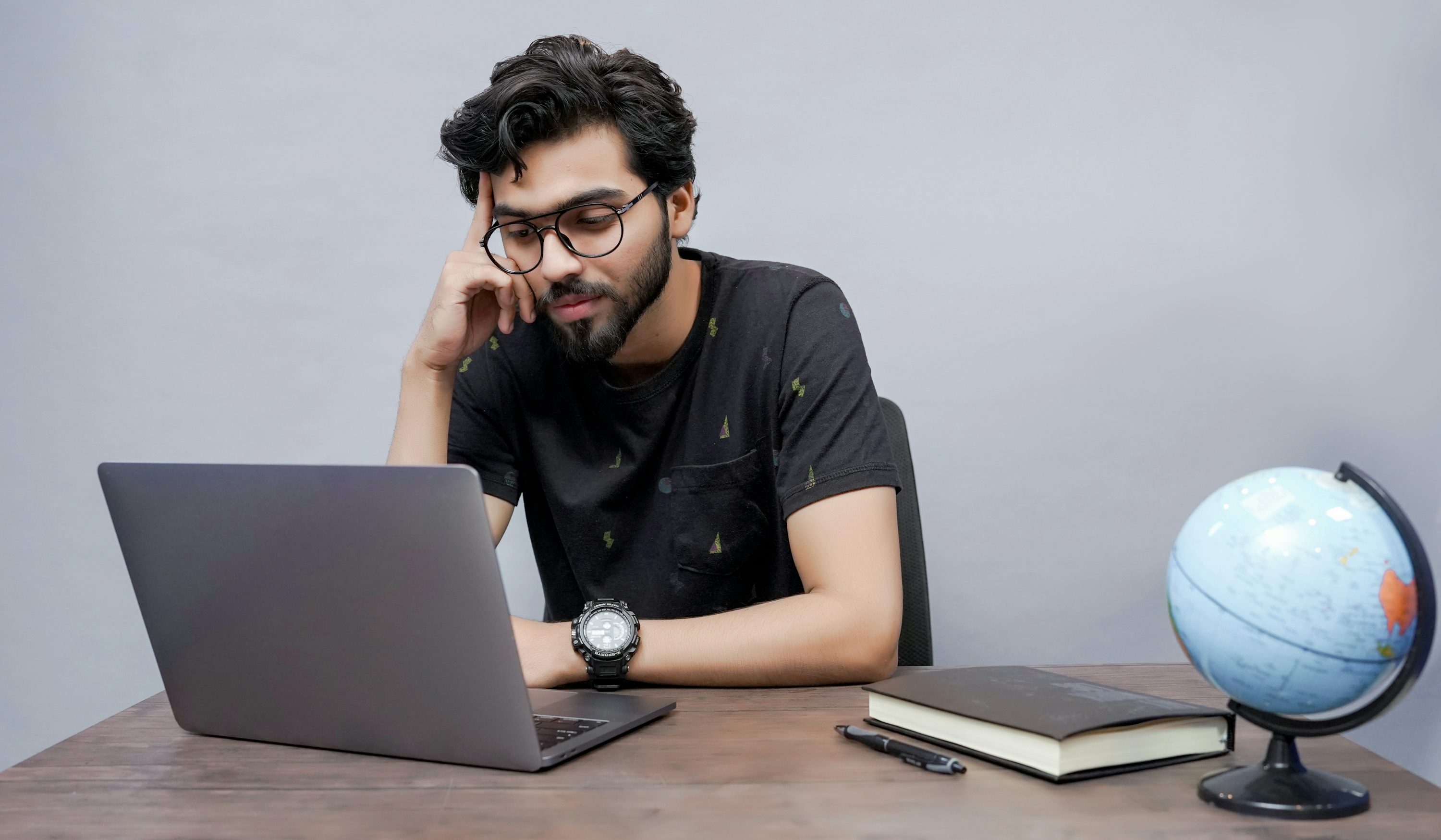 a man sitting in front of a laptop computer - How To Use A Trading Bot