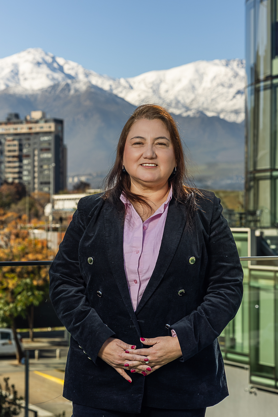 Retrato de Carolina Lobos con fondo de ciudad y montañas