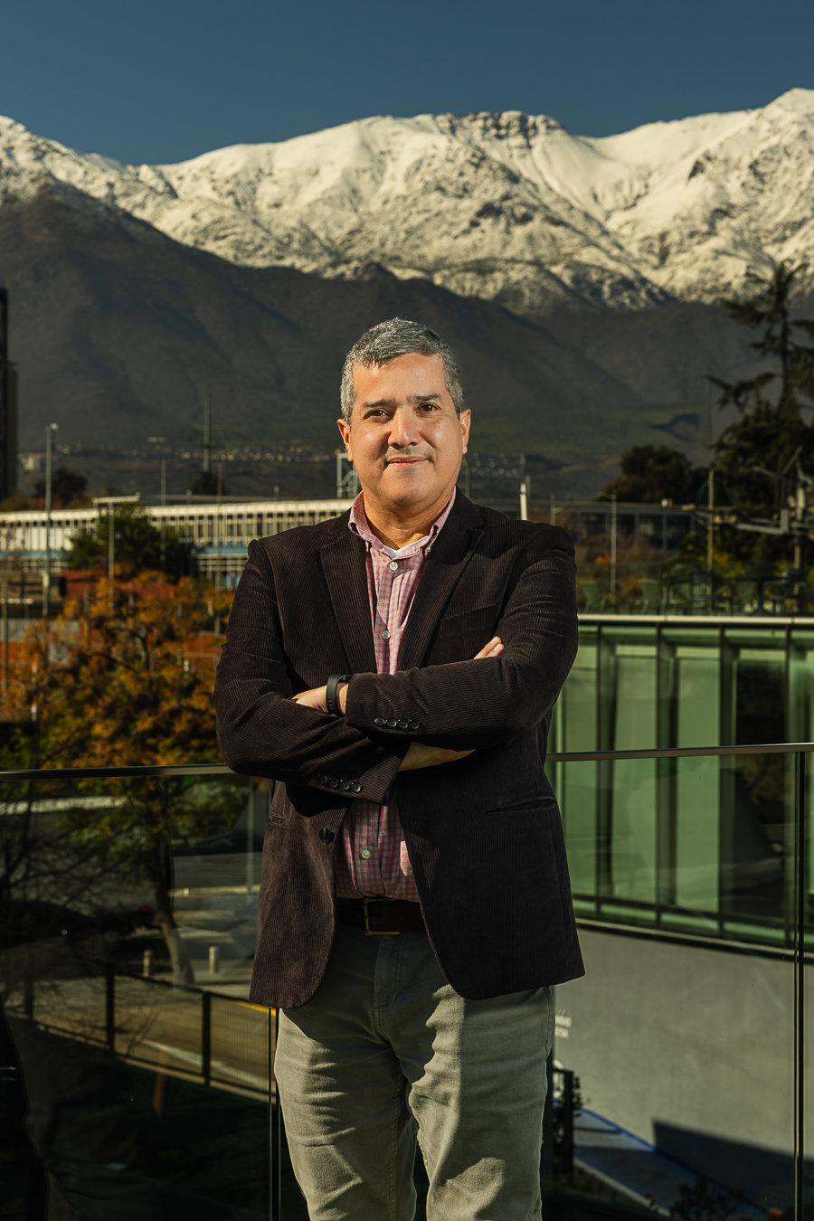 Retrato de Jorge Parra con fondo de ciudad y montañas