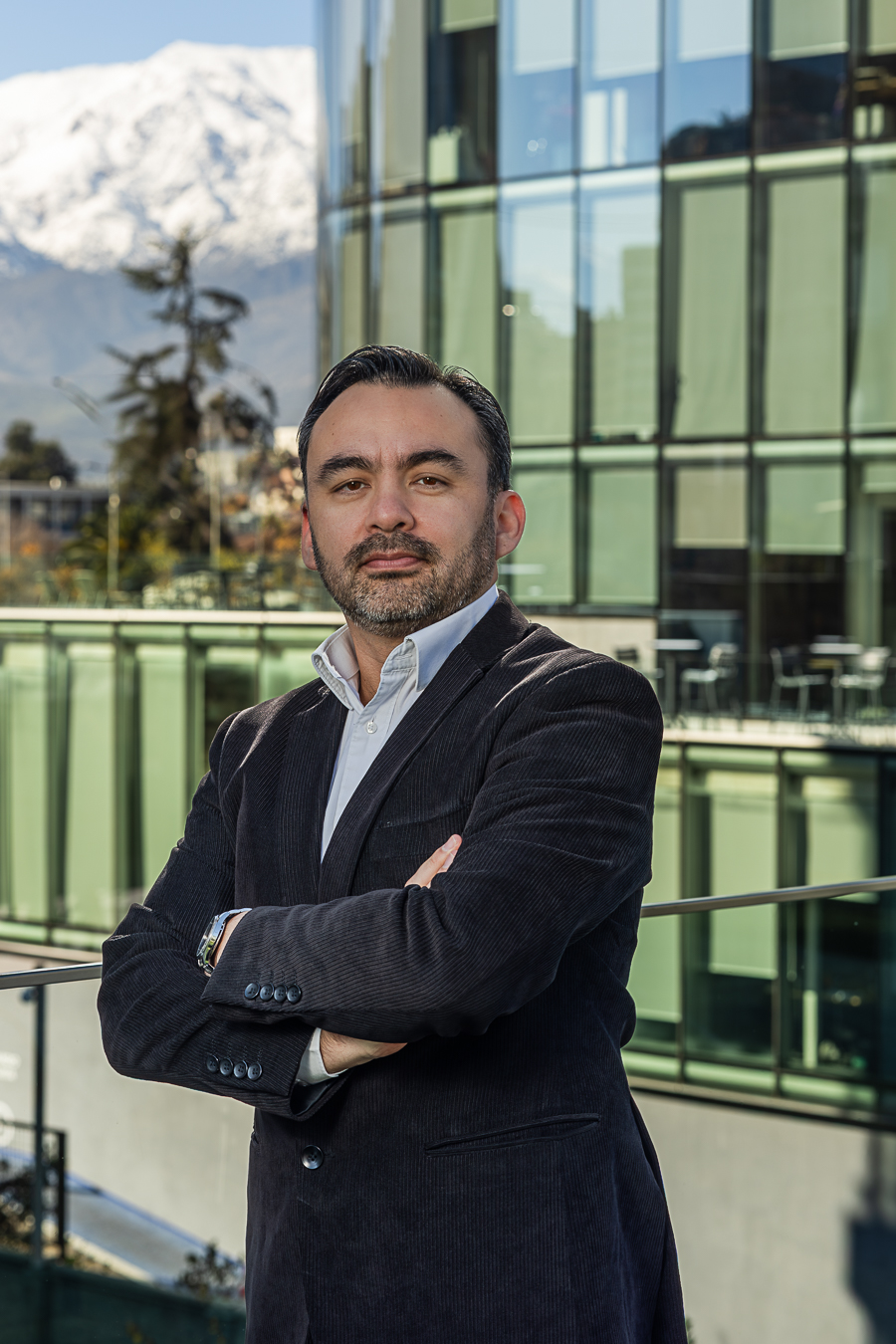 Retrato de Juan Labra con fondo de ciudad y montañas