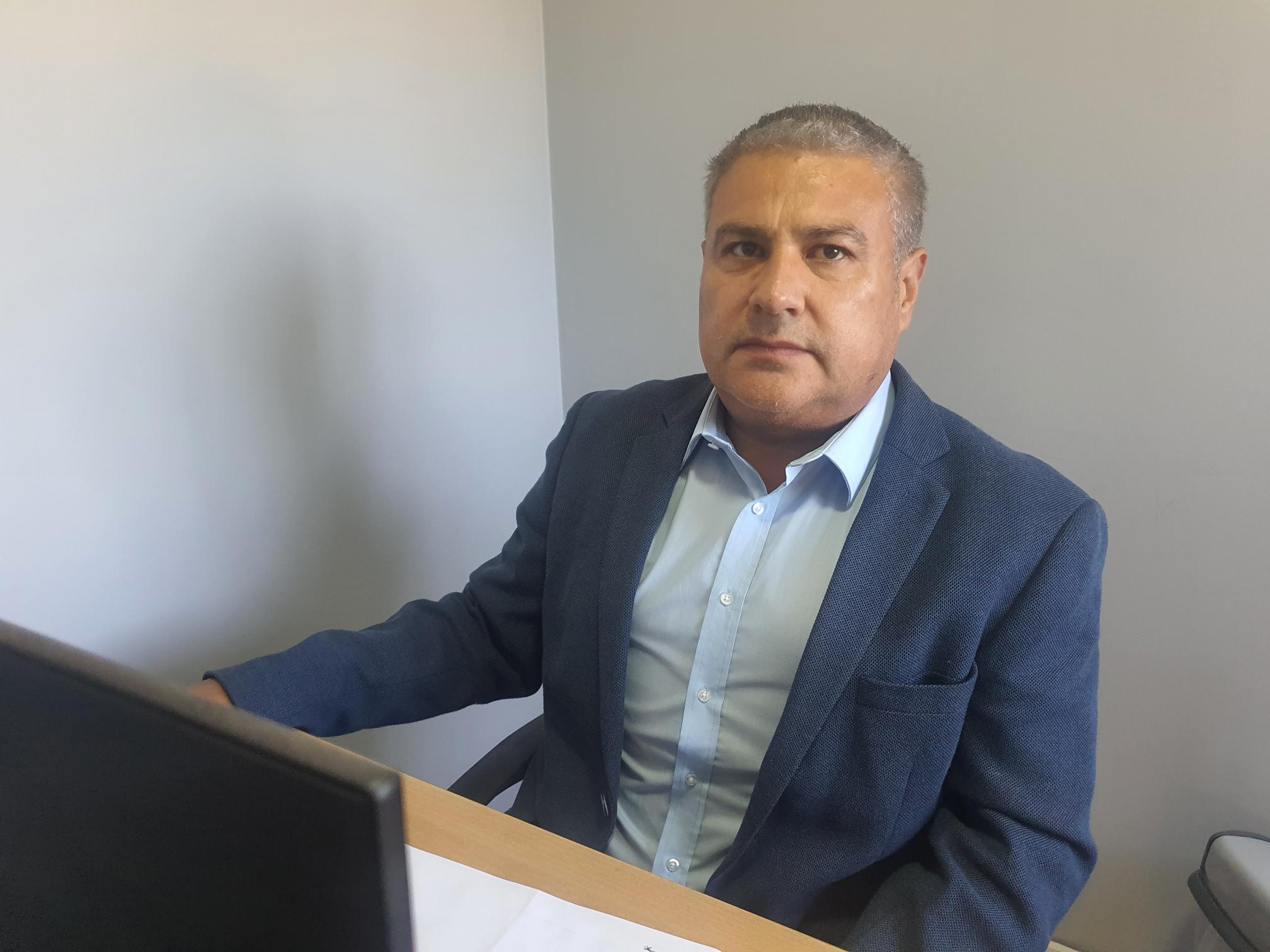 Retrato de Freddy Suarez con fondo de ciudad y montañas