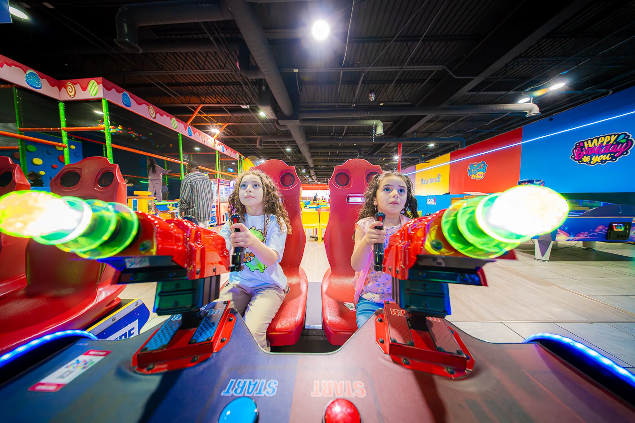 Two girls playing a racing arcade game at Yoyo’s Fun Center