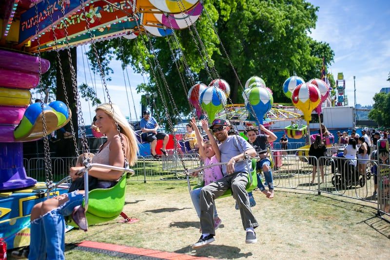 People enjoy rides and games at the Portland Rose Festival City Fair