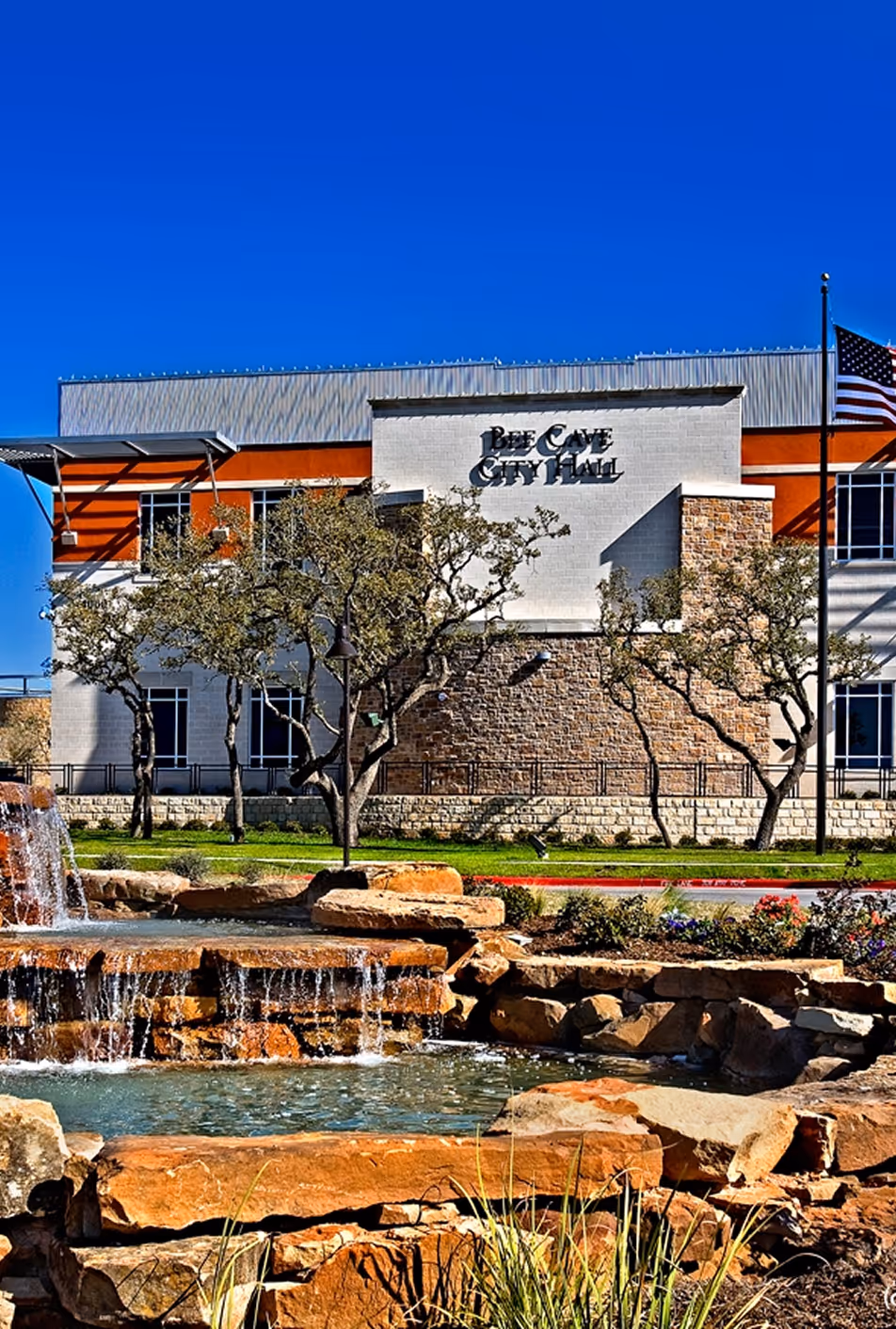 A waterfall in front of a building with a sign that says "Bay City Hotel."