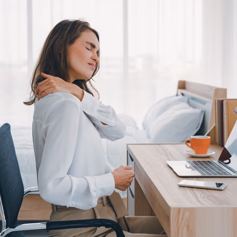 A woman with a sore back sitting in a chair.