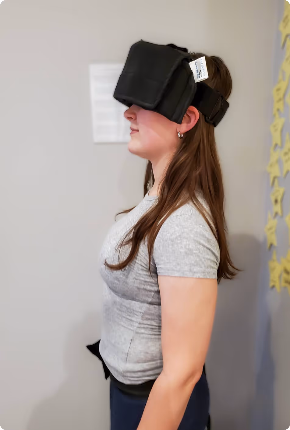 A woman wearing a black headset with a sticker on it.