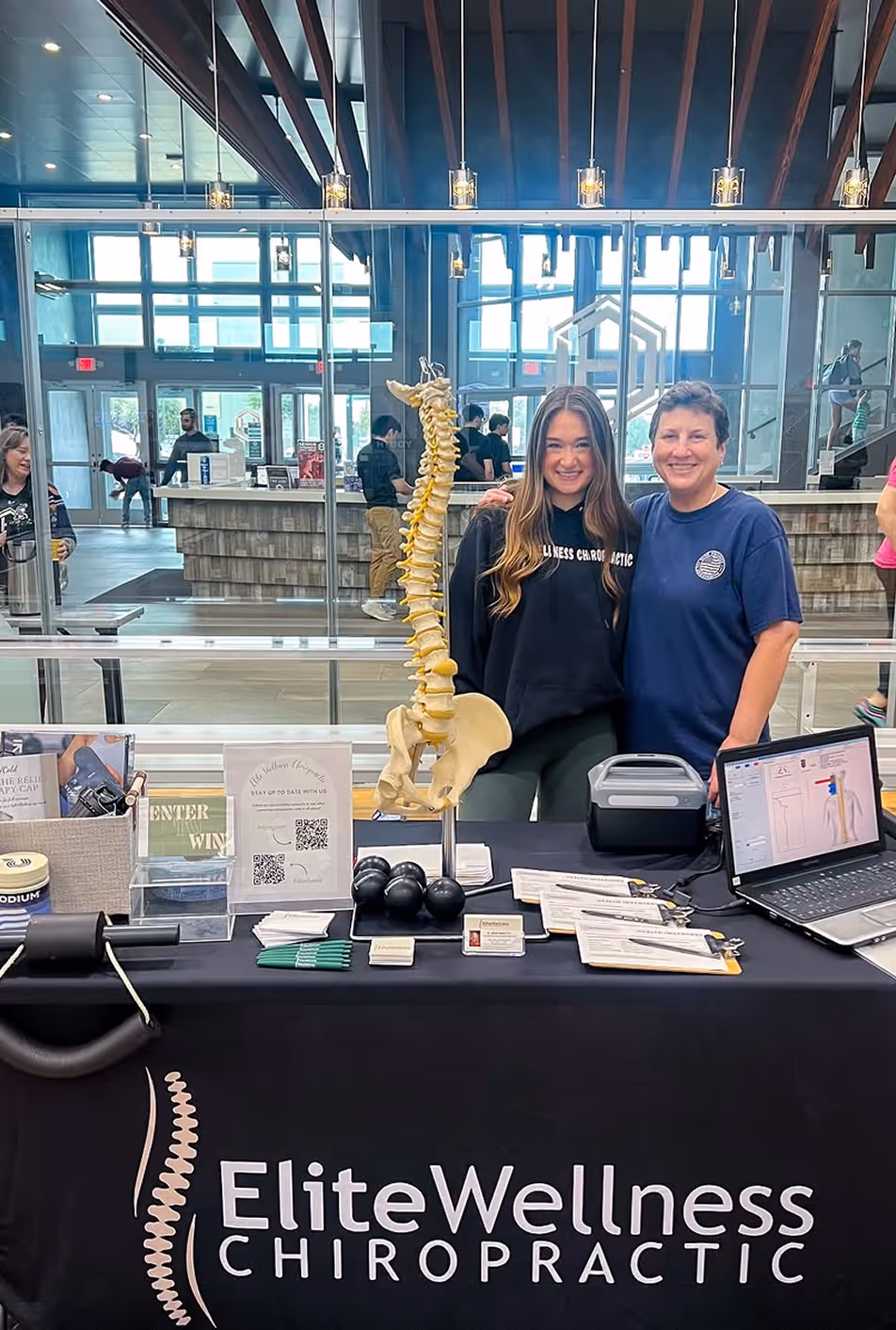 A woman posing with a spine model.