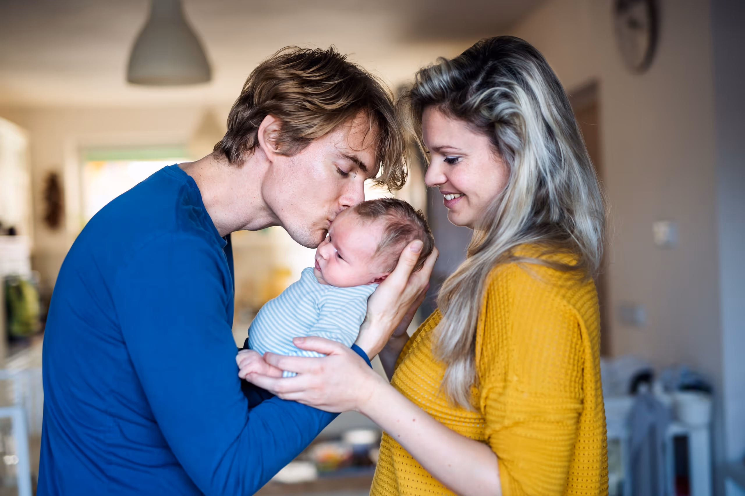 Parents holding their baby at home, representing child advocacy and family support in West Virginia.
