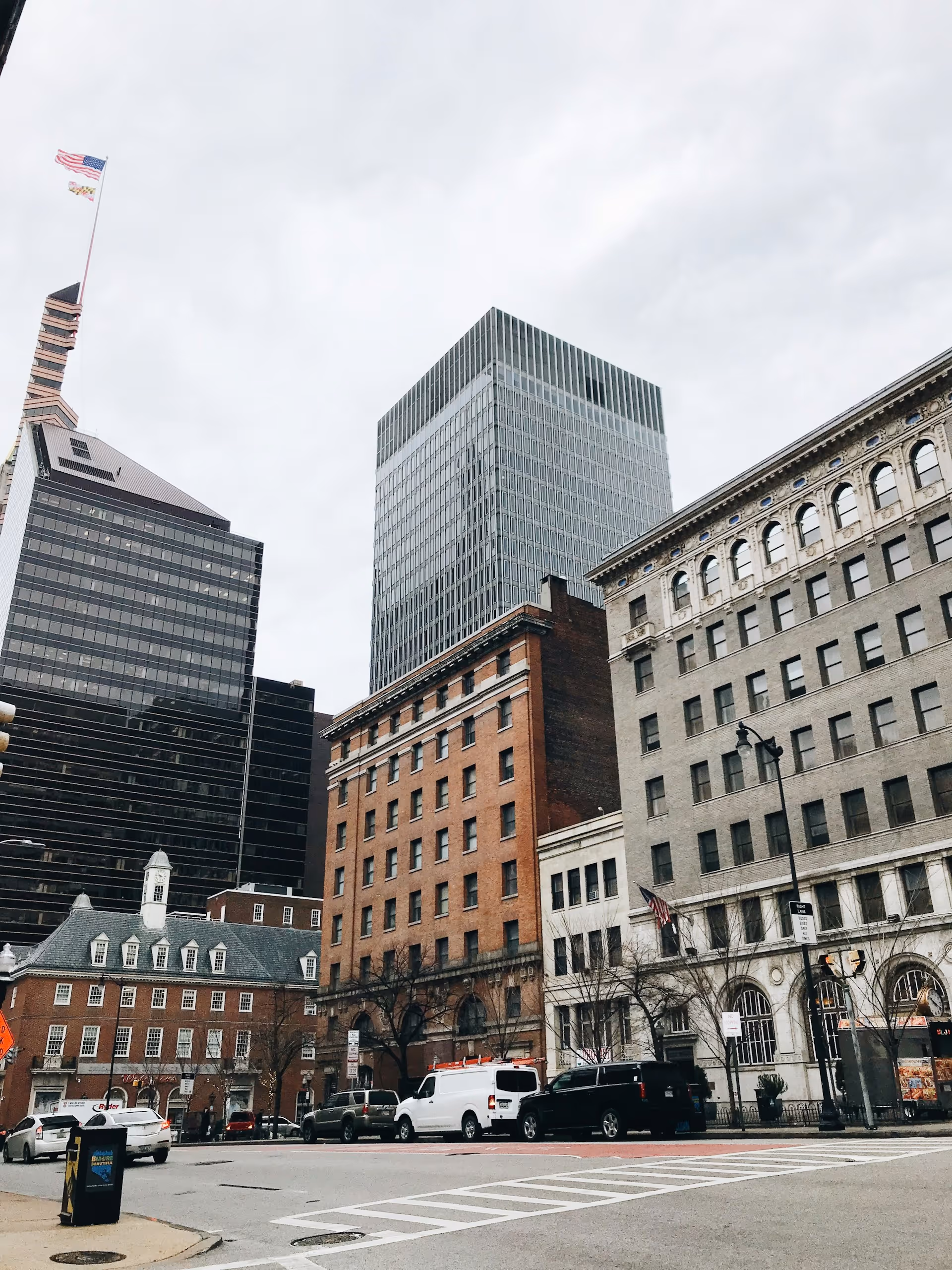 Downtown Baltimore street with historic and modern buildings.