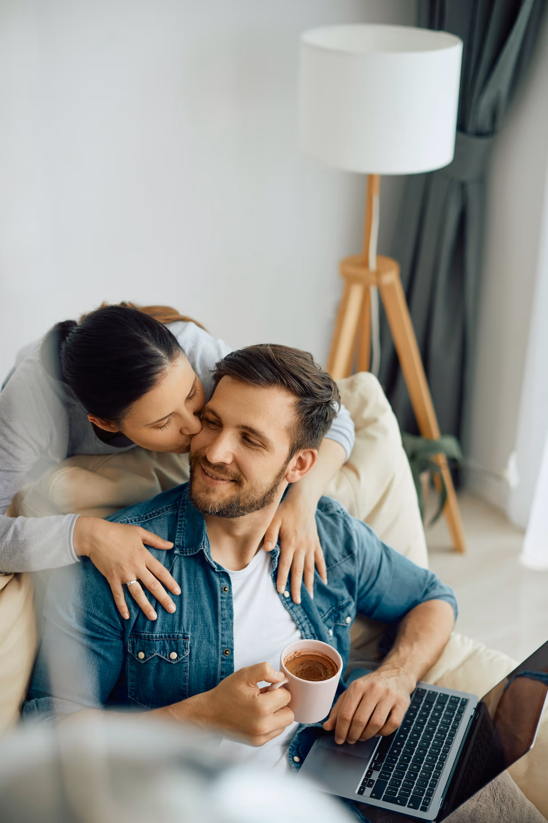 Smiling family relaxing together in a bright living room, representing comfort and belonging.
