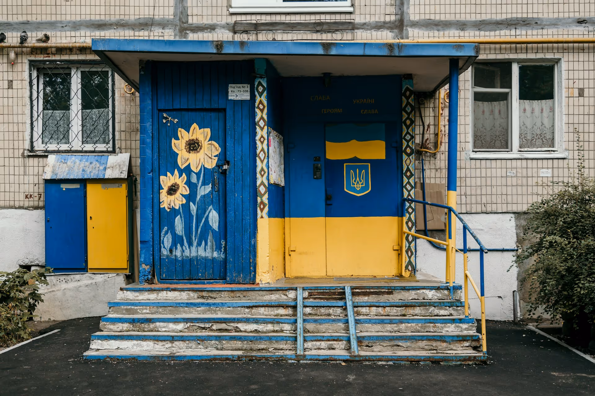 Building entrance painted in Ukraine’s blue and yellow colors, symbolizing recovery and rebuilding efforts.